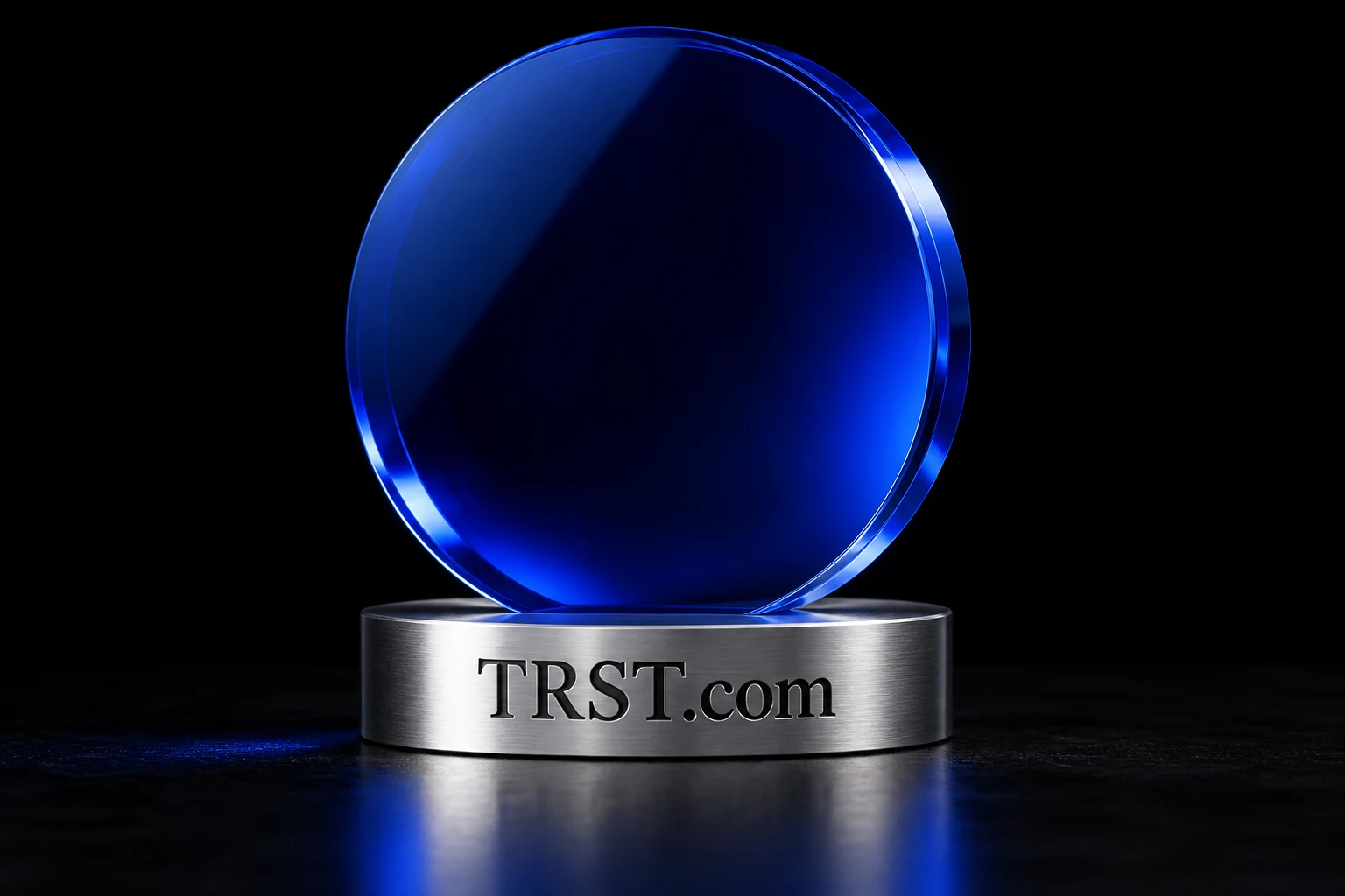 TRST.com engraved in an optical glass sculpture on brushed metal